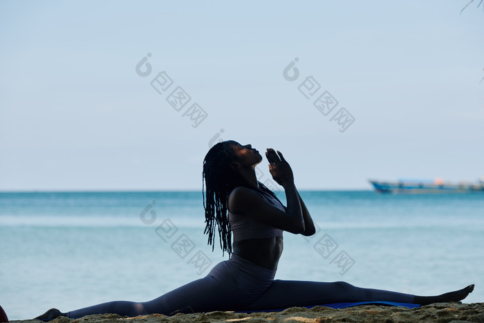 在海边做瑜伽劈叉的女子