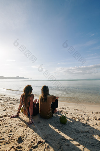 坐在沙滩上的朋友摄影图