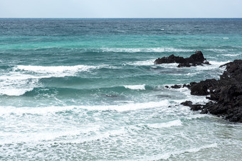 海浪浪花冲刷沙滩摄影图