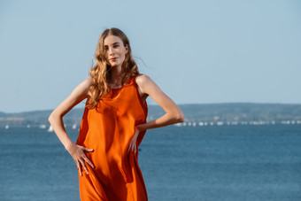 海边穿橙色连体衣的女人