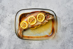 烤鱼上的柠檬摄影图