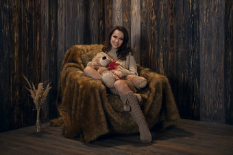 女孩抱着<strong>玩具熊</strong>坐在沙发上