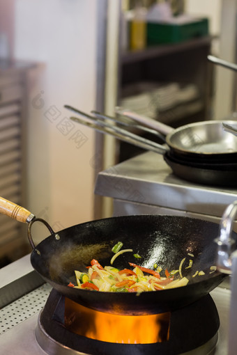 厨房油锅上正在翻炒的蔬菜