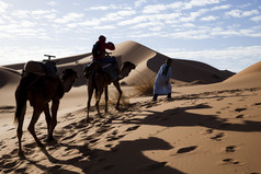 在沙漠里骑骆驼的人