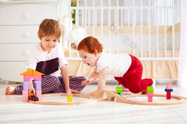 快乐的孩子，兄弟及木制玩具铁路苗圃房间里玩