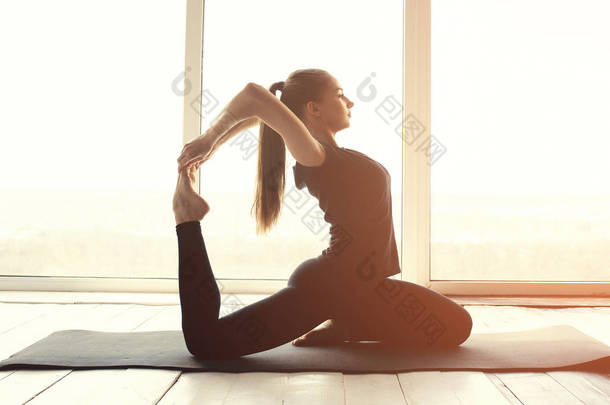 年轻美丽的女子练习瑜伽和体操。健康的概念。单项体育的班级.