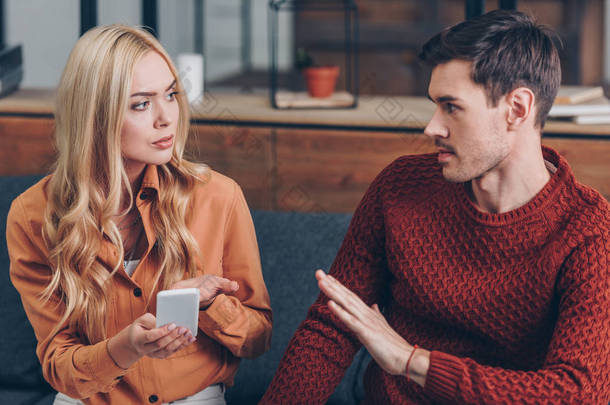 年轻夫妇争吵关于智能手机和看着对方, 关系问题的概念