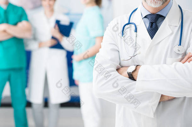 在医院工作的专业医疗队和自信的医生摆出双臂交叉的前景