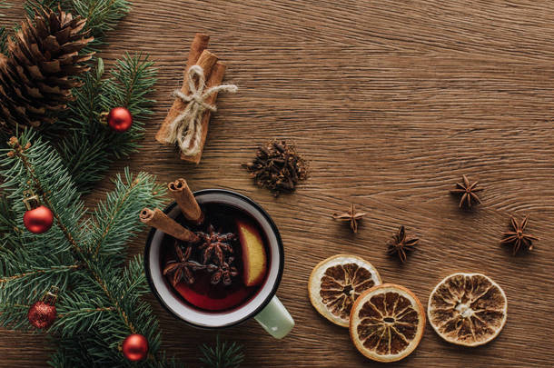 在木制桌面, 圣诞节概念的热葡萄酒, 干桔子和杉木树枝的小玩意的顶部视图