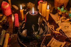 用香、木制祈祷珠、蜂蜡蜡烛、草药和桌子上的小魔法物燃烧黑色头骨蜡烛