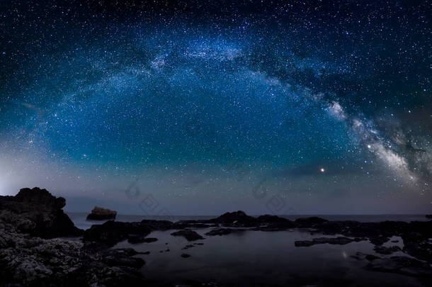 惊人的充满活力的银河图像在岩石悬崖和海, 夜景 