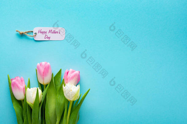 带快乐<strong>母亲节</strong>字母的纸标签和带复制空间的蓝色表面郁金香的顶部视图