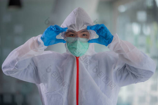 科学家们在实验室里戴着面具、手套和<strong>防护服</strong>.