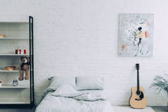 高角度的现代卧室与架子, 吉他和绘画在白色砖墙 