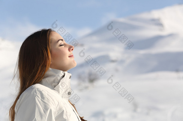 资源管理器中女人呼吸新鲜的空气在冬天在一座雪山
