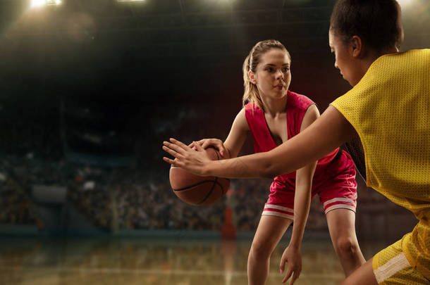 女篮球运动员为球而战。篮球运动员在大型专业竞技场上比赛