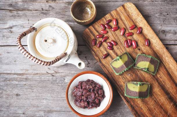 传统节日绿色中国月饼与红豆的木质背景
