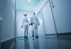 穿着防护服的研究人员穿过实验室大厅。病毒和疾病安全概念