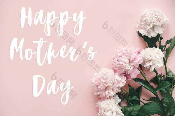 母亲节快乐短信在牡丹平面上。粉红和白色牡丹边框上柔和的粉红色纸