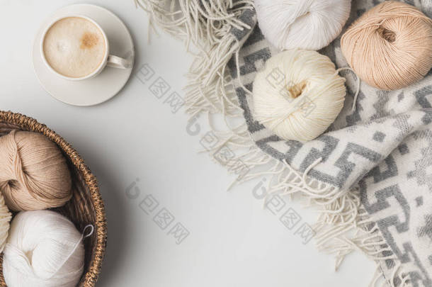 白色背景下的<strong>柳条</strong>篮、咖啡杯和毛毯的纱球顶视图