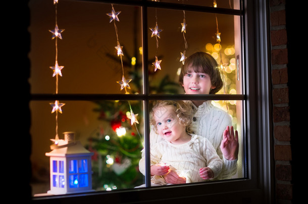 孩子们在圣诞节前夕的窗口