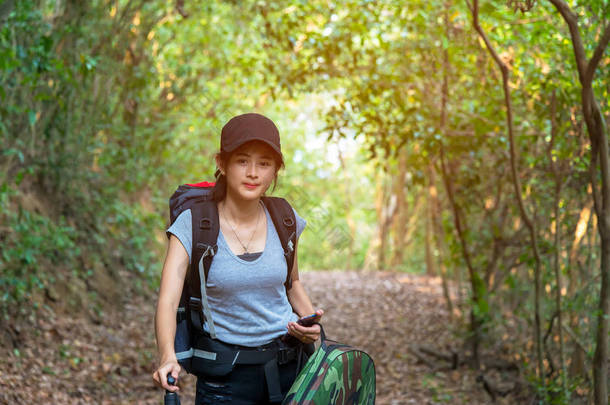 徒步旅行的年轻妇女在国家公园步行与背包。女游客去森林露营。旅游理念