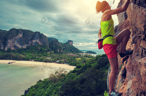 女人在海边悬崖攀登