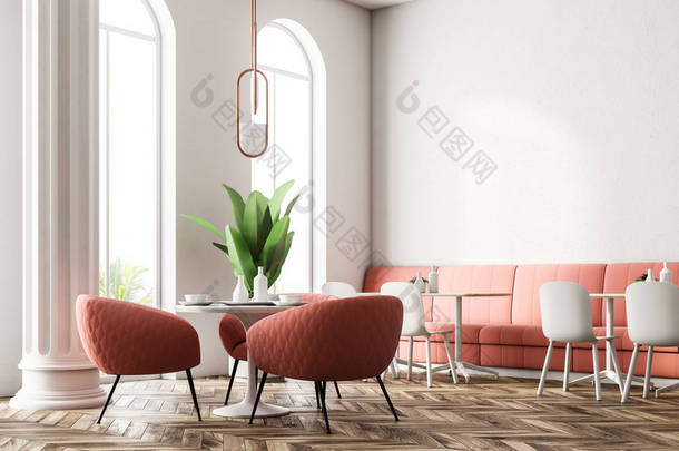 圆形桌子, 粉红色的扶手椅站在附近。大窗口和列。现代餐厅内有粉红色沙发。3d 渲染