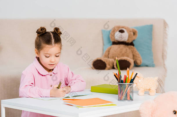 可爱的小孩拿着铅笔在家学习