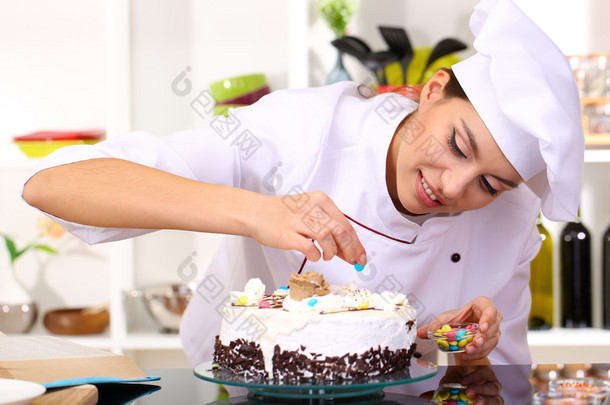 年轻女子厨师烹饪厨房里的蛋糕