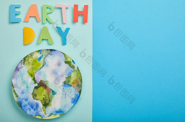五颜六色的纸质信件和行星图片的顶视图在绿色和蓝色背景, 地球天概念