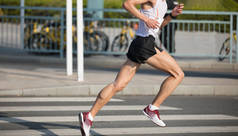 马拉松运动员腿在城市道路上奔跑