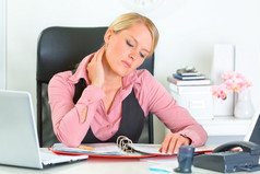 累了的商务女人坐在办公室桌前和工作