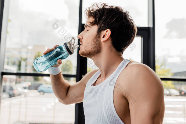 闭眼、喝水、拿着运动瓶的运动员侧视图