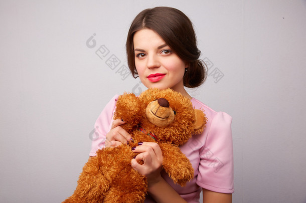 一个带着<strong>玩具熊</strong>的年轻女人