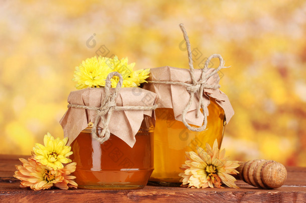 蜂蜜和木 drizzler 在黄色<strong>背景</strong>上的<strong>表</strong>上的两个 jars