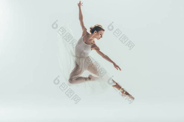 美丽的芭蕾舞演员在白色的礼服跳在工作室, 在白色隔离