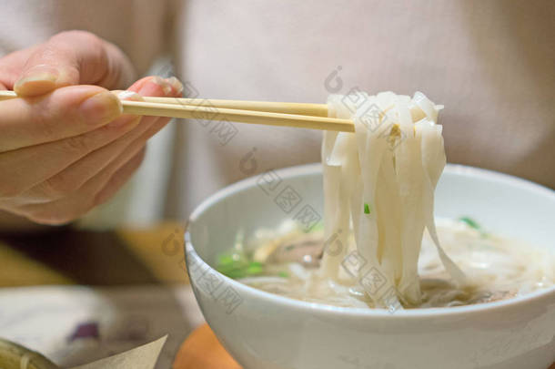 吃越南经典面条汤的妇女.