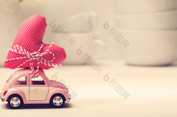 微型粉红色的车携带红色心形靠垫 