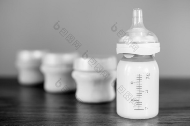 Baby bottle with milk and a measuring scale