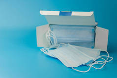 外科保护膜。医用呼吸绷带盒面对蓝色背景的口罩短缺。预防病毒和大流行病COVID-19的传播.