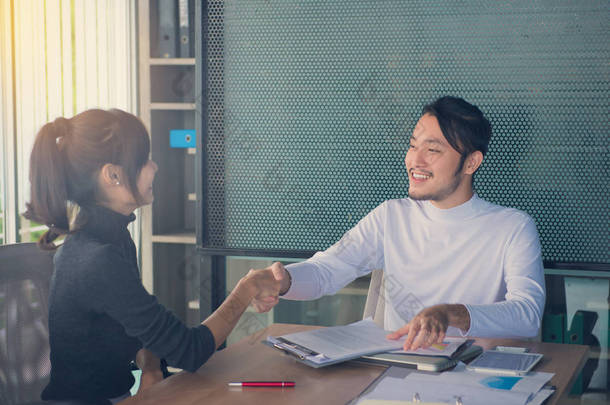 在会议中或在办公室里，业务伙伴关系会议概念谈判业务人握手.