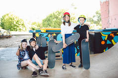 一群朋友，运动员，滑板手在一个滑板公园里摆出一副姿势。白人儿童一起在运动城市室外区域玩滑板。儿童体育俱乐部.