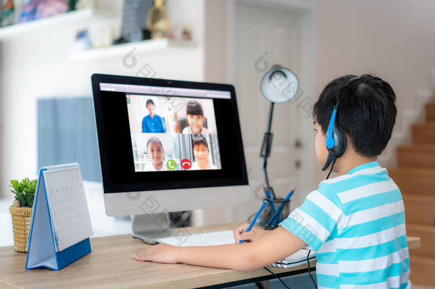 在家里客厅里，与老师和同学在电脑上进行电子学习。家庭学习和远程学习，在线、教育和互联网.