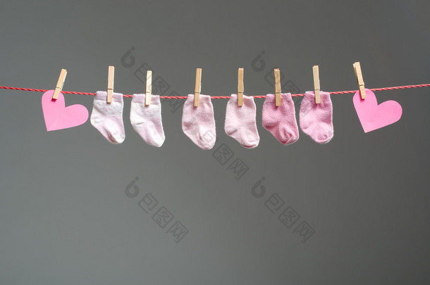 宝贝女孩袜子和纸的晾衣绳的心