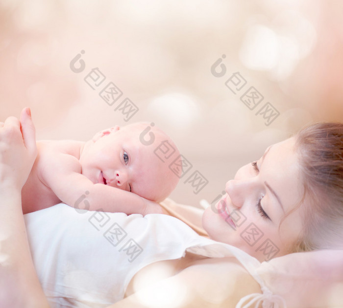 幸福的母亲和她刚出生的婴儿亲吻和拥抱