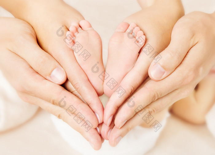 刚出生的婴儿脚在父母手中爱辛博尔作为心脏