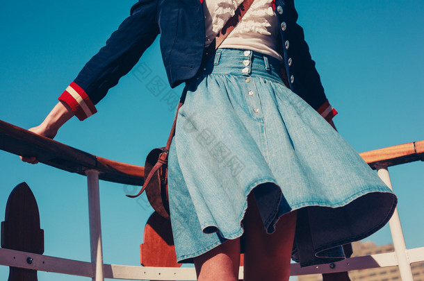 年轻女子的<strong>裙</strong>在风中飞扬着的船甲板上