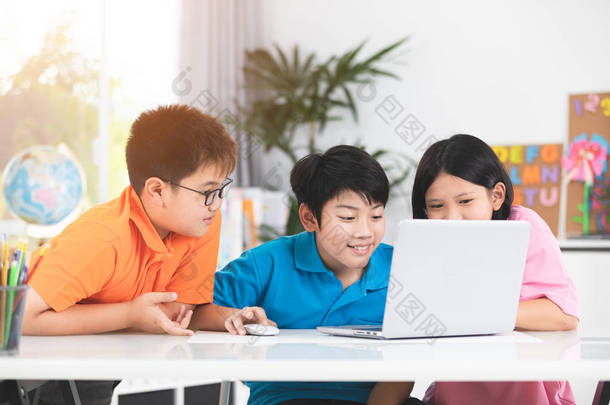 可爱的亚洲儿童使用膝上型电脑和笑脸.