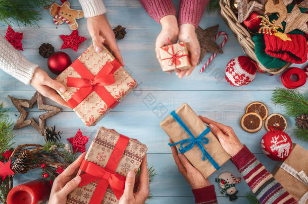 <strong>圣诞快乐</strong>, 节日快乐!祖母, 母亲, 父亲和他们的女儿准备礼物。鲍比, 礼物, 糖果与装饰品。顶部视图。圣诞节家庭传统.
